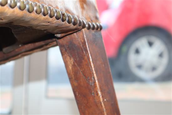 A George III mahogany hide-covered wing chair